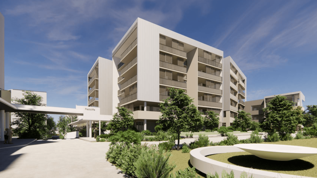 Modern apartment buildings with white facades, surrounded by lush greenery and landscaped gardens under a clear blue sky. An open plaza with a circular bench is in the foreground.